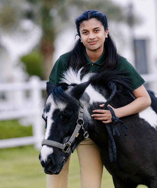 Close-up of an ADEC Pony Club rider with her black and white pony